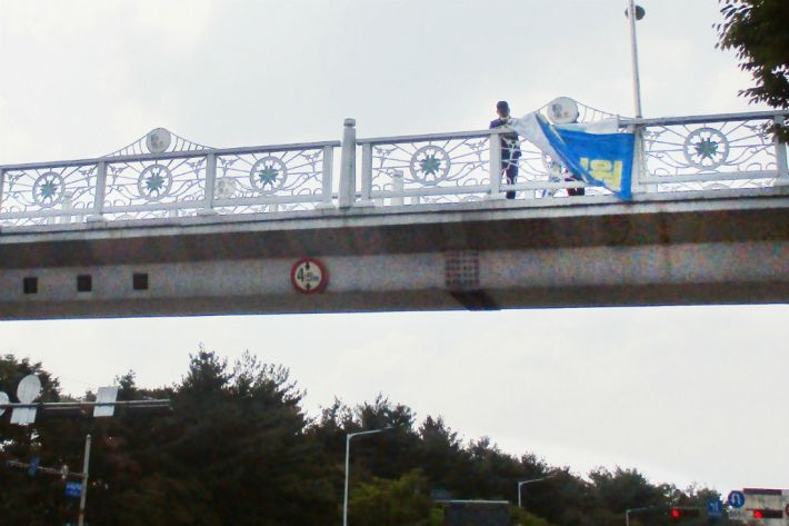 태풍 북상에 대비해 육교 위에 설치된 현수막이 철거되고 있다. (사진=대전 서구 제공)