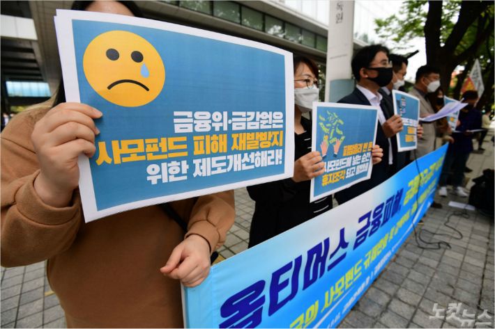 21일 오전 서울 여의도 금융감독원 앞에서 열린 ‘옵티머스 펀드 금융사기, 책임방기한 금융당국과 금융사 규탄’ 기자회견 참석자들이 손피켓을 들어보이고 있다. 황진환기자