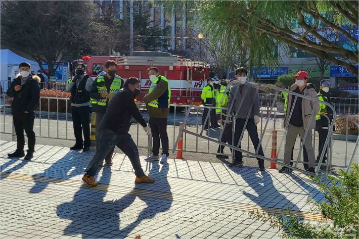 30일 한 5월 단체 회원이 경찰이 철창 앞에 철제 펜스를 설치하려고 하자 강하게 반발했다. (사진=김한영 기자)