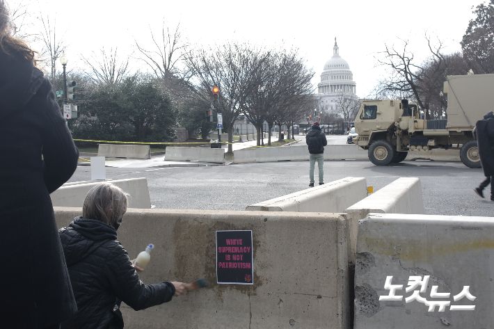'백인 우월주의는 애국이 아니다'고 적힌 전단을 붙이고 있는 시민단체 회원들. 권민철 기자