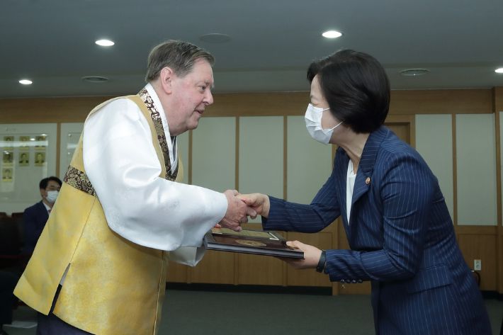 지난해 9월 국적증서를 수여받는 안광훈 신부(왼쪽). 연합뉴스