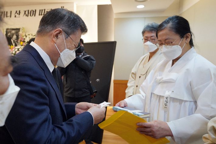 문재인 대통령이 17일 오전 서울 종로구 서울대병원 장례식장에 마련된 고(故) 백기완 통일문제연구소장 빈소를 조문, 유족으로부터 고인의 저서를 건네받고 있다. 연합뉴스