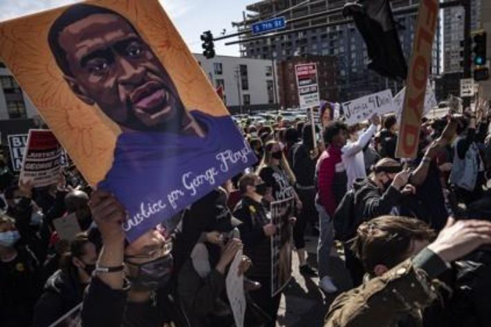 지난 8일(현지시간) 미 미네소타주 미니애폴리스에서 '조지 플로이드에게 정의를' 등이 쓰여진 포스터를 든 시위대가 행진하고 있다. 연합뉴스