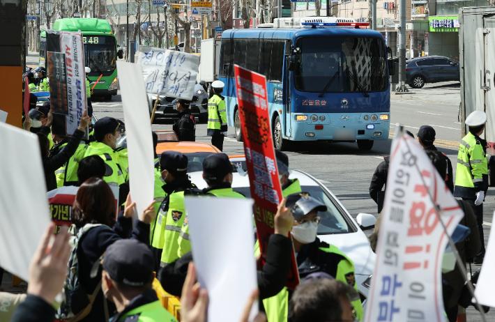 16개월 된 입양 딸 정인 양을 학대해 숨지게 한 혐의를 받는 양부모의 공판이 열린 17일 오후 서울 양천구 남부지방법원에서 시민들이 양모가 탄 호송차량을 향해 항의하고 있다. 연합뉴스