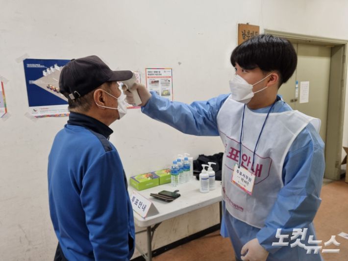 부산시장 보궐선거일인 7일 오전 부산 서구 남부민2동 제4투표소에서 보호복을 입은 선거사무원이 발열 체크를 하고 있다. 박진홍 기자