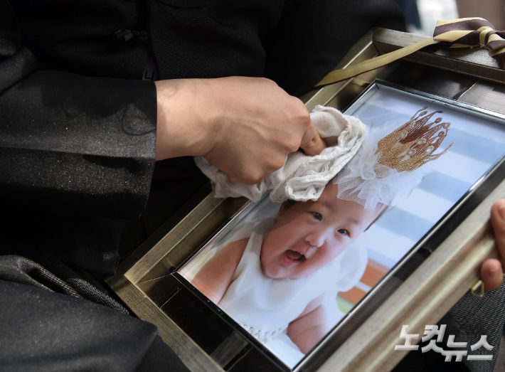 생후 16개월 된 정인 양을 학대해 사망에 이르게 한 양모 가 1심에서 무기징역을 선고받은 14일 오후 서울 양천구 서울남부지법 앞에서 한 시민이 정인이 사진을 끌어안은 채 눈물을 흘리고 있다. 서울남부지법 형사합의13부(이상주 부장판사)는 14일 살인 등 혐의를 받는 양모 장씨에게 무기징역을 선고했다. 아동복지법상 아동학대 등 혐의를 받는 양부에게는 징역 5년을 선고헸다. 이한형 기자