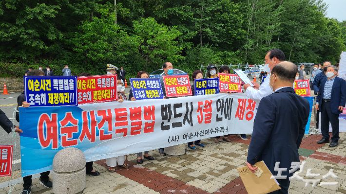 18일 여순사건여수유족회 회원들은 민주의 문 앞에서 현수막을 설치하고 5월 안에 반드시 여순사건 특별법이 제정돼야 한다고 촉구했다. 김한영 기자