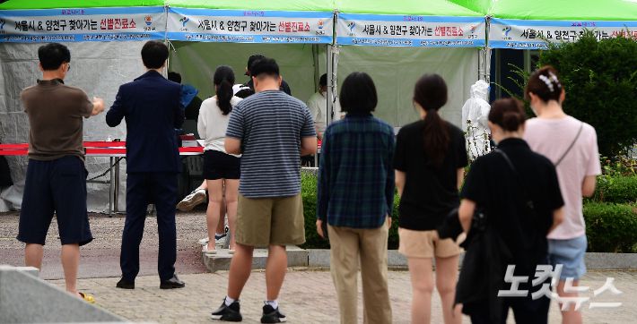 코로나19 신규확진자 수가 1100명으로 역대 월요일 발표 수치 중 최다를 기록한 12일 오전 서울 양천구 파리공원에 설치된 '찾아가는 선별진료소'를 찾은 시민들이 코로나19 검사를 받기 위해 줄서 기다리고 있다. 황진환 기자