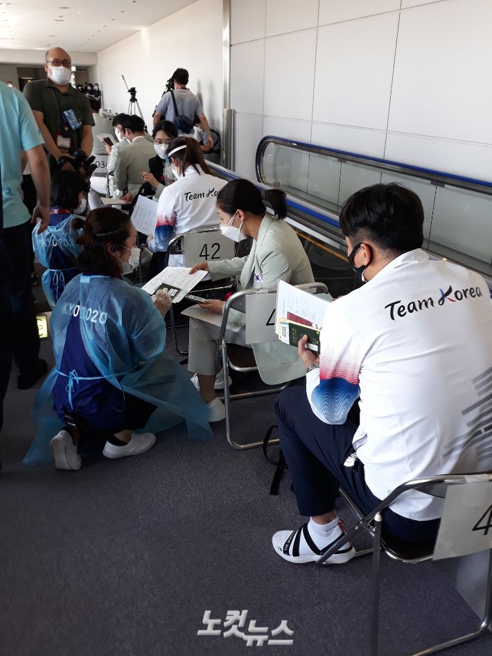도쿄올림픽 선수단과 취재진은 비행기에서 내려 나리타 공항에 발을 내딛자마자 환영 인사보다 코로나19 관련 서류 심사와 타액 검사를 받아야 한다. 사진은 19일 입국한 한국 선수단이 대회 조직위원회 관계자에게 서류를 제출하는 모습. 도쿄=노컷뉴스