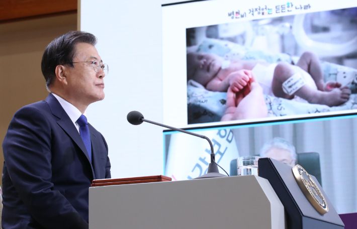 문재인 대통령이 12일 청와대 본관에서 화상을 통해 열린 건강보험 보장성 강화대책 4주년 성과 보고대회에서 김용익 국민건강보험공단 이사장의 건강보험 보장성 강화대책 성과 발표를 듣고 있다. 연합뉴스