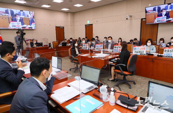 국민의힘 윤한홍 간사 등 의원들이 지난 24일 국회 법제사법위원회 전체회의에서 '언론중재법 개정안' 반대 문구를 내걸고 회의에 참석하고 있다. 윤창원 기자