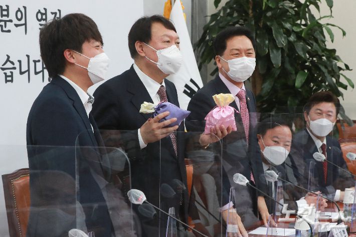 윤석열 국민의힘 대선후보(왼쪽 두번째)가 8일 오전 서울 여의도 국회에서 열린 최고위원회의에서 이준석 대표에게 비단주머니를 받고 발언하고 있다. 윤창원 기자