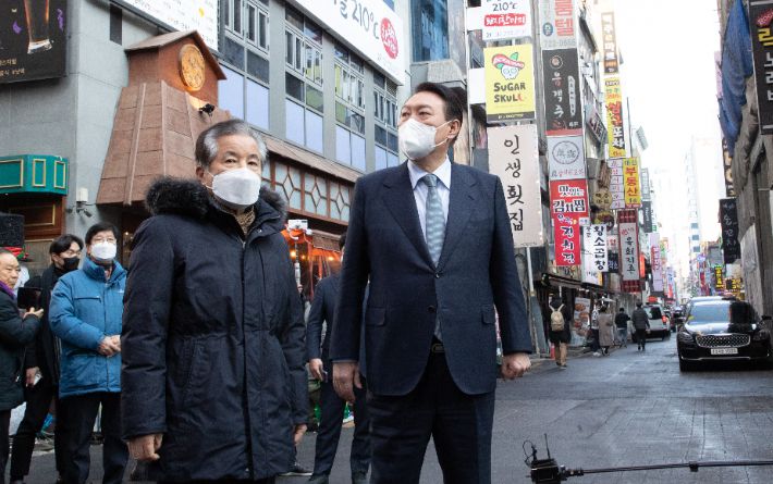 국민의힘 윤석열 대선 후보가 2일 오후 서울 종로구 한 음식점에서 열린 코로나19 자영업 피해 현장 간담회에 앞서 강한식 종로구관철동문화발전위원회 회장으로부터 현장 설명을 듣고 있다. 연합뉴스
