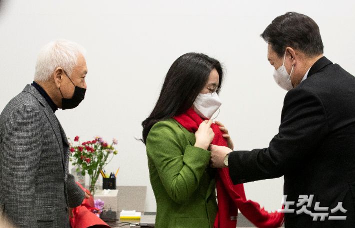 지난달 20일 여의도 새시대 준비위원회 위원장실에서 국민의힘 윤석열 대선후보가 신지예 한국여성정치 네트워크 대표에게 영입 환영의 목도리를 걸어줬던 모습. 황진환 기자
