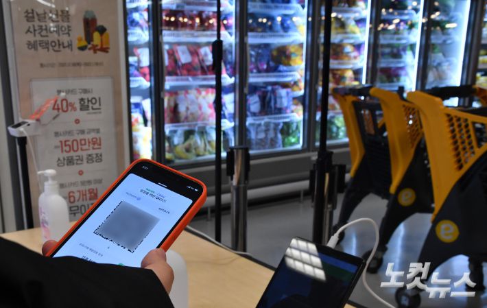경기도 하남시 한 마트에서 한 시민이 방역패스 유효 상태를 확인하고 있다. 박종민 기자