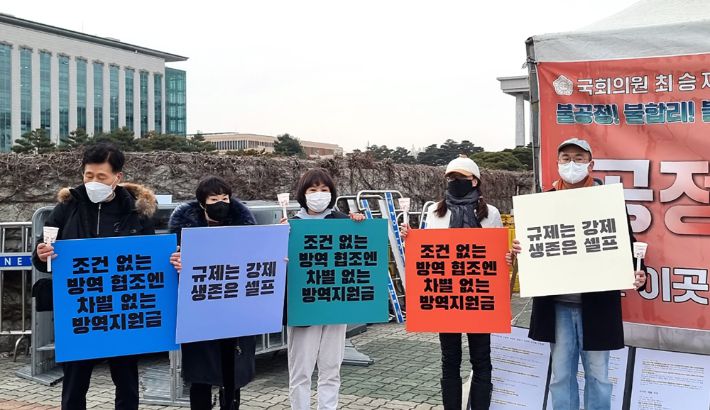 7일 오후 서울 여의도 국회의사당 앞에서 자영업연대 주최로 열린 방역정책 규탄 촛불집회에서 자영업자들이 손팻말을 들어 보이고 있다. 연합뉴스