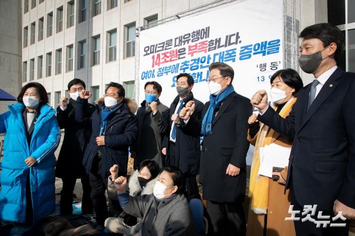 더불어민주당 이재명 대선후보가 8일 국회 본청 앞에서 오미크론 대응을 위해 추경안 대폭증액을 요구하며 농성을 벌이는 민주당 의원들과 함께 추경 증액을 촉구하는 구호를 외치고 있다. 윤창원 기자