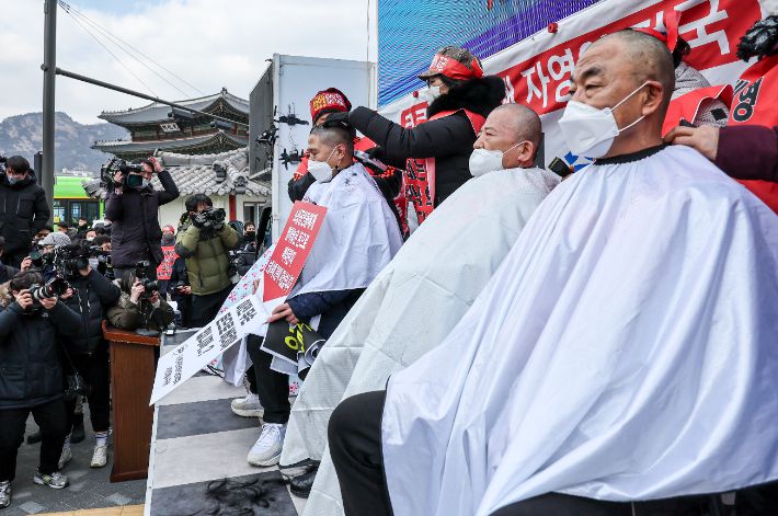 15일 오후 서울 광화문 열린마당에서 열린 ''코로나 피해 실질 보상 촉구 및 정부 규탄대회''에서 자영업자들이 삭발식을 하는 모습. 연합뉴스