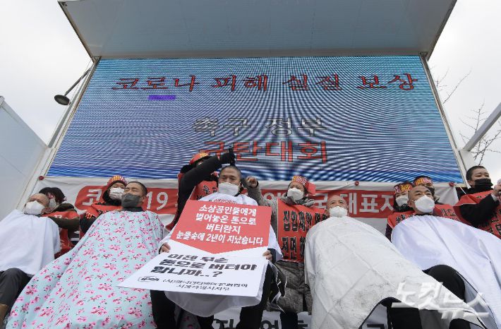 코로나피해자영업총연합(코자총) 참석자들이 지난 15일 서울 광화문 시민열린마당에서 열린 '코로나 피해 정부 규탄 결의대회'에서 삭발식을 갖고 있다. 이한형 기자