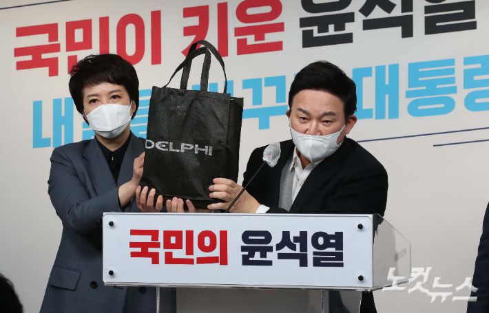 원희룡 국민의힘 정책본부장이 25일 서울 여의도 국민의힘 당사에서 열린 대장동 관련 긴급 기자회견에서 입수한 자료가 들어 있던 가방을 들어보이고 있다. 윤창원 기자