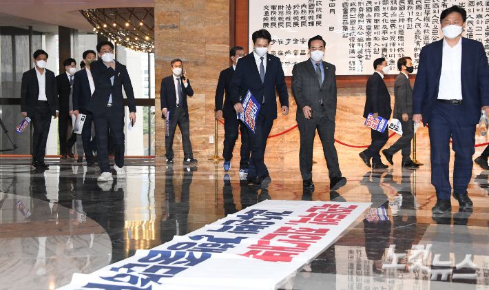 더불어민주당 박홍근 원내대표와 의원들이 로텐더홀에 국민의힘 의원들이 펼쳐놓은  검수완박 규탄 현수막을 보며 검찰청법 개정장을 처리하기 위해 본회의장에 입장하고 있다. 박종민 기자