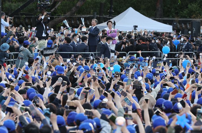 문재인 대통령이 9일 오후 청와대 앞 분수대에서 퇴근길 마중 나온 시민들에게 케이크를 받은 뒤 인사하고 있다. 연합뉴스