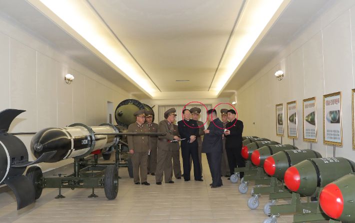 북한 김정은 국무위원장은 지난 27일 핵무기연구소에서 최근 사업정형과 생산 실태를 보고받았다고 28일 조선중앙통신이 보도했다. 사진은 김 위원장이 관계자들로부터 보고를 받는 모습으로 김 위원장 곁에 있는 남성 2명의 얼굴이 모자이크 처리(붉은색 원)됐다. 이들의 계급이 중장(별 2개) 혹은 소장(별 1개)으로 추정돼 실무진으로 보인다. 연합뉴스