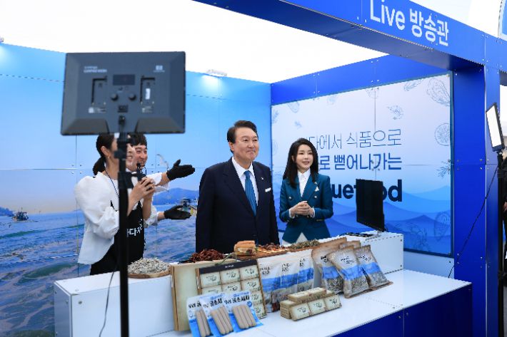 윤석열 대통령과 김건희 여사가 31일 경남 통영 영운항에서 열린 '제12회 수산인의 날' 기념식 수산물 홍보 부스에서 진행된 통영 수산물 판매 라이브 방송에 출연하고 있다. 대통령실 제공