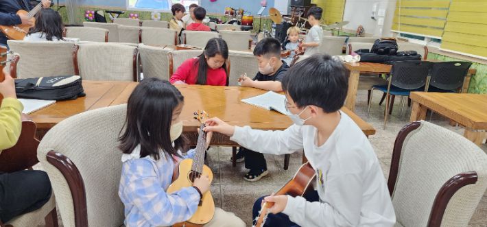 매주 2회 악기 배우는 시간에 선배가 후배를 지도하는 모습. 박명훈 장로 제공