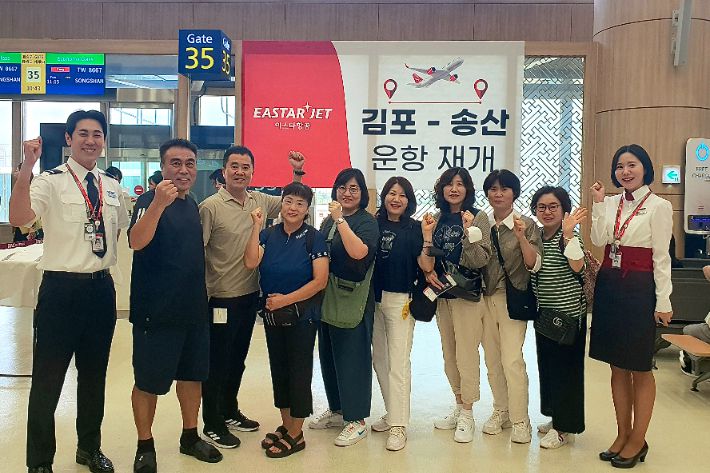 이스타항공 국제선 첫 운항편을 통해 타이베이로 동창 여행을 떠나는 승객들이 승무원들과 게이트 앞에서 기념 촬영을 하고 있다. 이스타항공 제공
