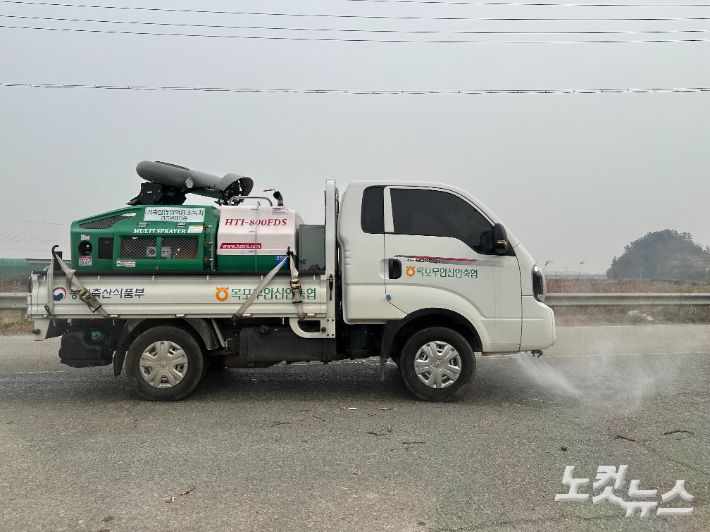 방역 차량이 6일 전남 무안읍 일로읍의 한 오리농장 주변도로에서 소독약을 살포하고 있다. 김한영 기자