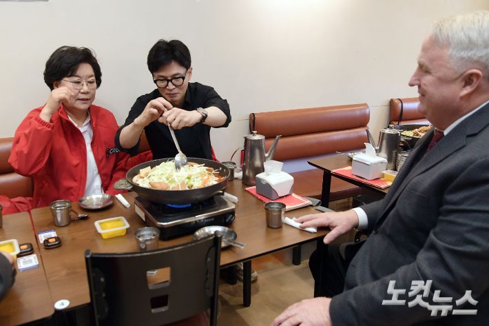 국민의힘 한동훈 비상대책위원장 겸 총괄선거대책위원장이 25일 서울 중구 신당동 떡볶이 타운 한 식당을 이혜훈 중구성동구을 후보, 국민의미래 인요한 선거대책위원장과 함께 찾아 떡복이를 주문하고 국자를 들어 음식을 섞고 있다. 윤창원 기자