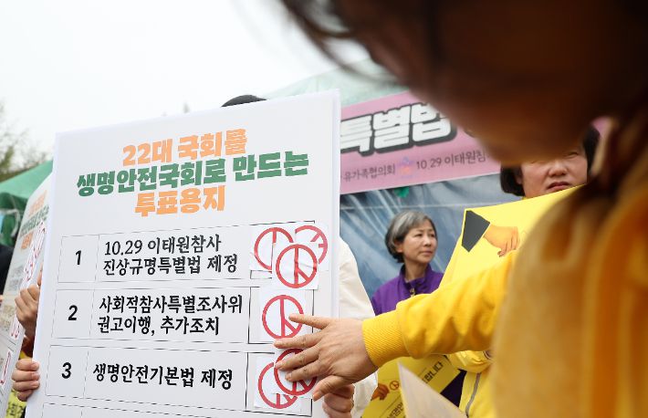 10·29 이태원참사유가족협의회와 4·16 세월호참사 가족협의회가 8일 오전 서울 영등포구 국회 앞에서 연 '생명안전 약속운동 기자회견'에서 참가자들이 투표지 손팻말에 스티커를 붙이는 퍼포먼스를 하고 있다. 연합뉴스