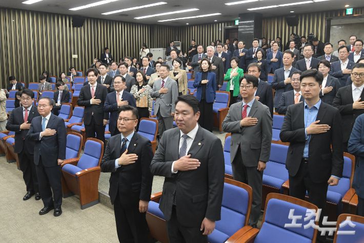 29일 서울 여의도 국회에서 열린 국민의힘 제22대 국회의원 당선자총회에서 윤재옥 원내대표 겸 당대표 권한대행 등 참석자들이 국민의례를 하고 있다. 윤창원 기자