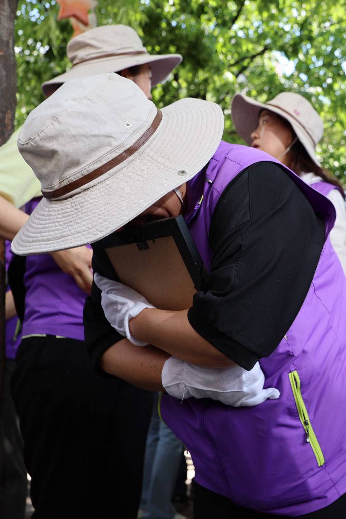 16일 오후 서울광장에 마련된 10·29 이태원 참사 합동 분향소에서 희생자 영정을 받은 유가족들이 눈물을 흘리고 있다.  이날 분향소는 서울광장에서 을지로1가 부림빌딩 1층 실내로 이전했다. 연합뉴스