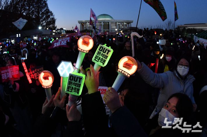 윤석열 대통령 탄핵소추안이 가결된 지난달 14일 서울 여의도 국회 앞에서 열린 촛불집회에 참석한 시민들이 탄핵이 가결되자 환호하고 있다. 류영주 기자