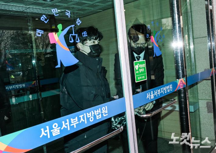 내란 수괴와 직권남용 등의 혐의를 받는 윤석열 대통령의 구속 전 피의자 심문(영장실질심사)이 열리는 18일 서울 마포구 서부지법에 윤 대통령이 탑승한 호송차량이 도착하자 서부지법 관계자들이 출입문을 잠그고 있다. 황진환 기자