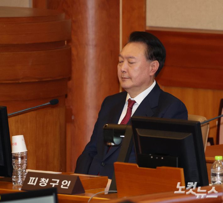 윤석열 대통령이 23일 오후 서울 종로구 헌법재판소 대심판정에서 열린 탄핵심판 4차 변론기일에 출석해 눈을 감고 있다. 사진공동취재단
