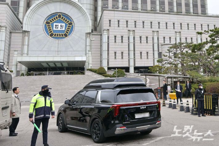 윤석열 전 대통령의 내란 혐의 첫 형사 재판이 열리는 14일 서울중앙지방법원으로 윤 전 대통령이 탑승한 차량이 들어가고 있다. 사진공동취재단