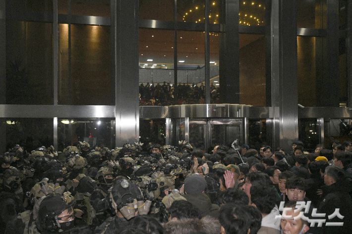 지난해 12월 3일 밤 윤석열 전 대통령이 비상계엄을 선포한 가운데 서울 여의도 국회에서 경내로 진입하려는 계엄군과 저지하려는 시민 및 국회 관계자들이 대치하고 있다. 박종민 기자