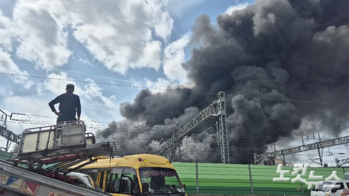 17일 오후 3시쯤 광주 광산구 소촌동에서 한 주민이 지게차 위에 올라가 솟구치는 검은 연기를 바라보고 있다. 한아름 기자