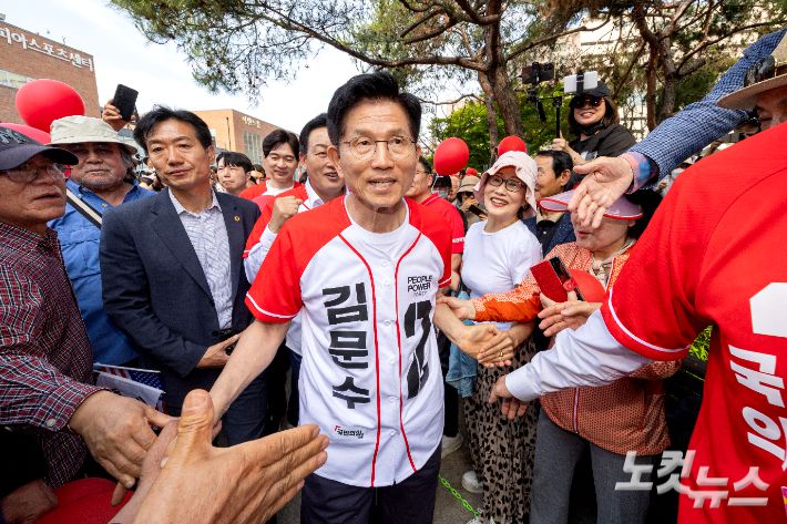 김문수 국민의힘 대선 후보가 26일 오후 경기 용인시 수지구 용인포은아트갤러리 광장에서 열린 내일의 기적을 만들 용인 집중유세에서 시민들과 악수하고 있다. 용인=황진환 기자