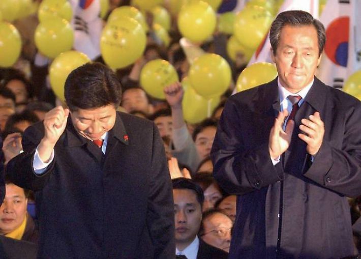 단일화를 이뤄낸 당시 노무현 후보(왼쪽)와 정몽준 후보가 2002년 12월 18일 서울 명동에서 공동유세를 벌이고 있다. 연합뉴스