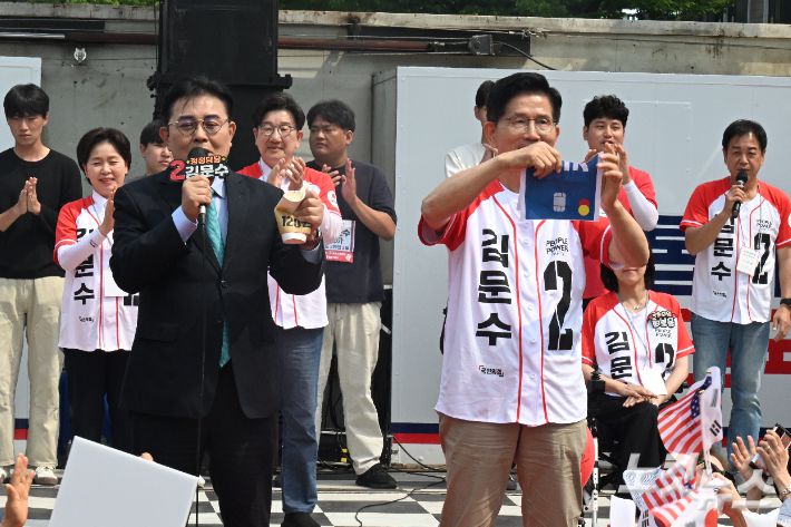 '120원'이 적힌 커피잔과 '법인카드'가 적힌 종이를 찢는 퍼포먼스를 하고 있는 국민의힘 김문수 대선 후보와 새미래민주당 전병헌 대표. 전영래 기자