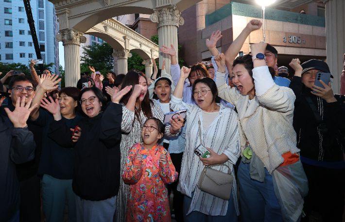 제21대 대통령 선거일인 3일 오후 더불어민주당 이재명 후보의 자택인 인천 계양구 아파트 주민들이 핸드폰으로 방송사 출구조사 결과를 보며 환호하고 있다. 연합뉴스