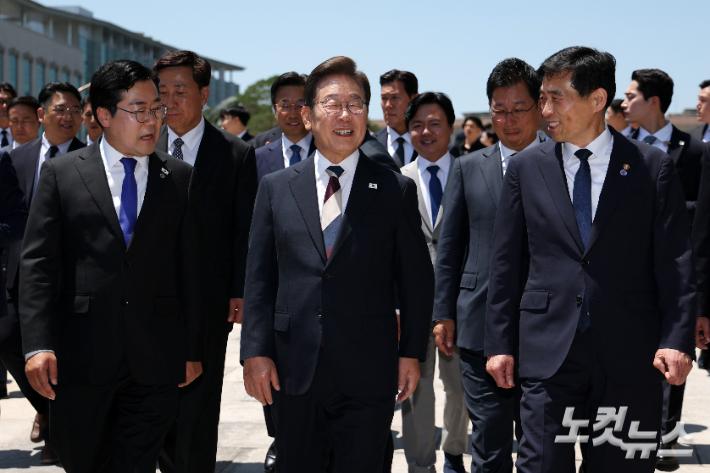 이재명 대통령이 4일 서울 여의도 국회 로텐더홀에서 취임 선서를 마친 뒤 우원식 국회의장 및 여야 6당 대표와 오찬을 위해 사랑재로 이동하며 박찬대(왼쪽) 더불어민주당 대표 직무대행과 김민기 국회 사무총장과 대화하고 있다. 윤창원 기자