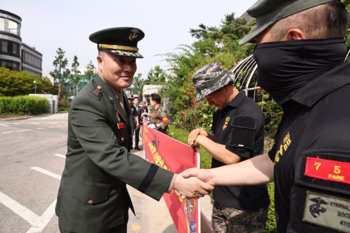 해병대 채모 상병 순직 사건과 관련해 1심에서 무죄를 선고받은 박정훈 대령(전 해병대 수사단장)이 13일 서초구 서울고등법원에서 열리는 2심 1회 공판에 출석하기에 앞서 법원 앞에서 참석자와 악수하고 있다. 연합뉴스