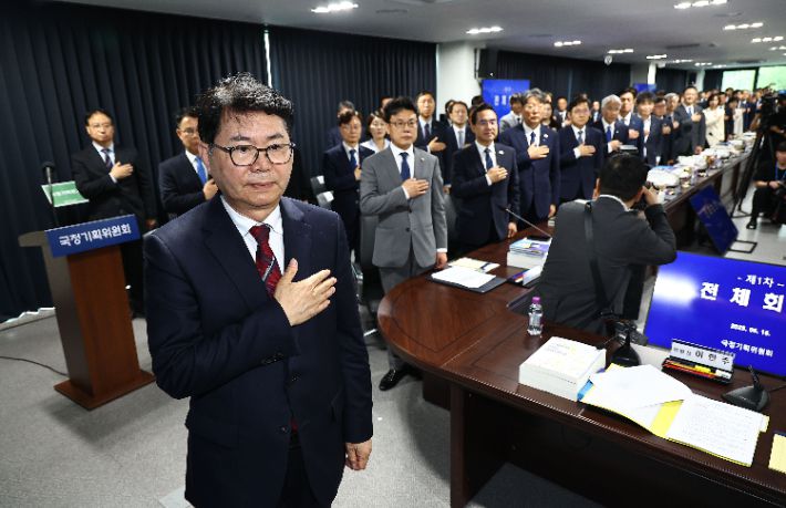 16일 서울 종로구 정부서울청사 창성동 별관에서 국정기획위원회 이한주 위원장과 참석 위원들이 회의에 앞서 국기에 경례하고 있다. 연합뉴스