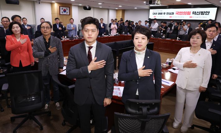 국민의힘 김용태 비상대책위원장(앞줄 오른쪽 세번째)과 참석한 의원들이 19일 서울 여의도 국회 의원회관에서 당의 혁신을 바라는 의원모임 주최로 열린 '대선 패배 후 민심과 국민의힘 혁신방안' 토론회에서 국기에 경례하고 있다. 연합뉴스