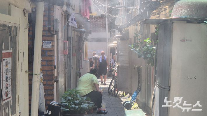 9일 전국 대부분 지역에 폭염특보가 내려진 가운데 서울 종로구 돈의동 쪽방촌 주민들이 골목에서 쿨링포그를 맞으며 더위를 식히고 있다. 송선교 기자